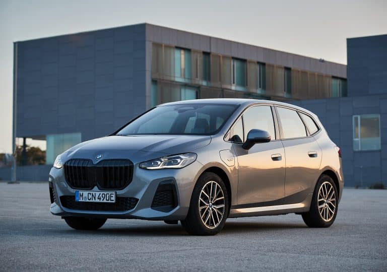 BMW Serie 2 Active Tourer grise garée sur un parking devant une zone industrielle
