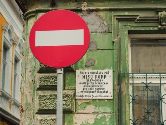 panneau sens interdit devant un vieil immeuble vert