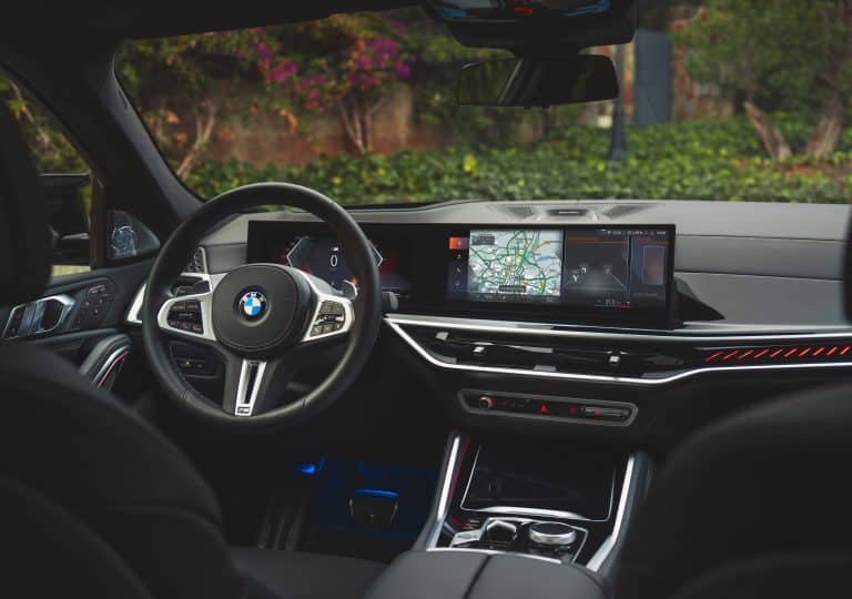 Vu de l'intérieur du tableau de bord d'un BMW X6 avec un paysage de forêt en arrière plan