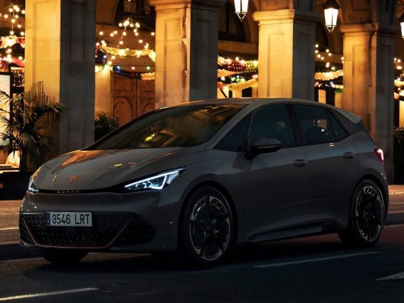 Cupra Born grise devant un hôtel illuminé pour faire ressortir le côté mystérieux de cette voiture