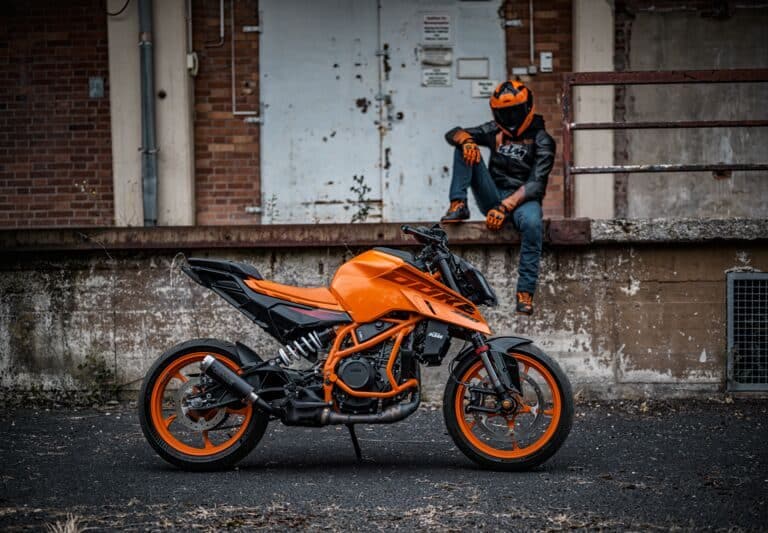 motard posant à côté de sa moto KTM 390 Duke orange adaptée au permis moto A1